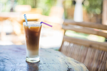 Iced coffee drink with plastic straw and plastic stirer, contributing to overuse of single use plastic contributing to global warming and climate emergency
