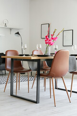 Dining table with setting and gladiolus flowers in room interior