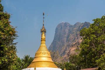 Fototapeta premium Gold stupa with Mount Zwegabin summit behind, Hpa An, Kayin State (Karen State), Myanmar (Burma)