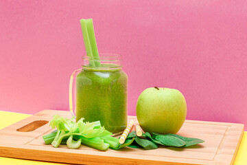 Fresh Green Smoothie of Apple, Celery, and Spinach in Glass Smoothie Jar with Yellow Cocktail Straw on Wooden Cutting Board. Vegan Detox Drink. Vegetarian Culture. Healthy Eating and Fruit Diet