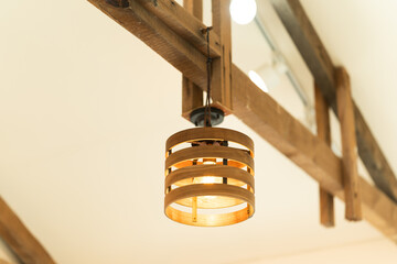 Rustic wooden lamp with yellow light bulb decoration hanging on the ceiling