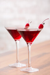 Glasses of tasty Manhattan cocktail on wooden table