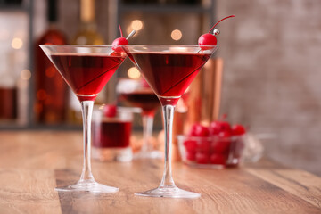 Glasses of tasty Manhattan cocktail on wooden table, closeup