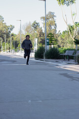 young athlete jogging in the outdoor park in the morning among nature