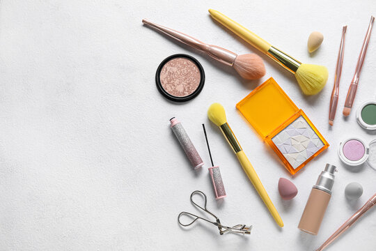 Different makeup products on light background