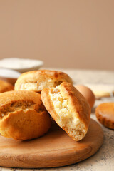 Wooden board of tasty sochniki with cottage cheese on table