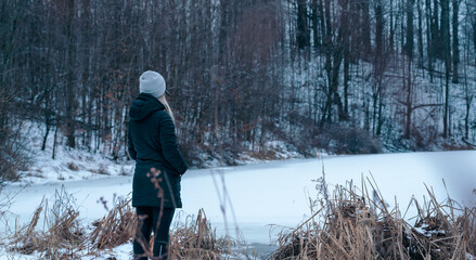 Woman stopping to take in the view in a forest on a cold winters day