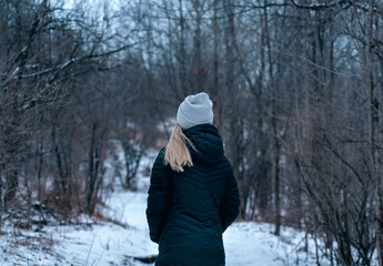 Woman taking a walk through the forest on a cold winters day