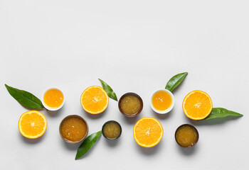 Composition with tasty orange jam and leaves on blue background