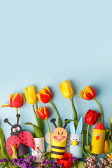 Happy easter spring toy collection and fresh flowers on blue background, kids holiday party concept background. Paper crafts, DIY. creative idea from toilet roll. reuse, recycle