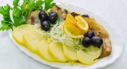Delicious fresh salad of potatoes, fish meat, lemon, olives and onions. Healthy food for real gourmets.