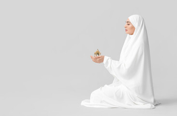 Fototapeta na wymiar Muslim woman with lamp on light background