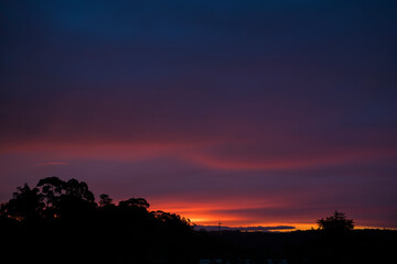 Sunset glow with a silhouetted landscape.