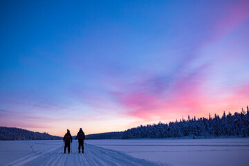 Skiing on the frozen lake at Torassieppi at sunset, Lapland, Finland