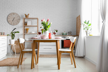 Dining table with stylish setting for International Women's Day celebration in room interior