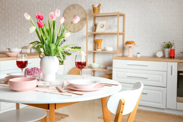 Dining table with beautiful setting for International Women's Day celebration in light room