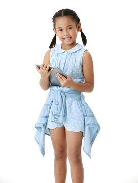 Portrait Full Body Studio Isolated Cutout Shot Of Asian Young Pigtail Braid Hair Little Girl Model In Blue Dress Standing Smiling Holding Tablet Computer  Look At Camera On White Background