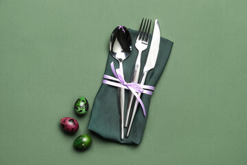 Beautiful cutlery for Easter celebration on green background