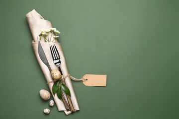 Beautiful cutlery for Easter celebration on green background