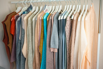 a lot of multi-colored knitwear on a rack in the showroom