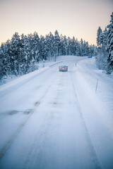 Car driving on icy snow covered roads on a road trip while travelling in Lapland inside the Arctic Circle in Finland