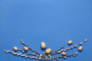 Beautiful Easter eggs and willow branches on blue background © Pixel-Shot