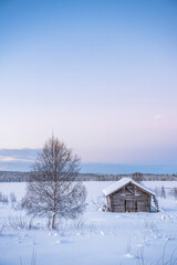 Cabin in a cold winter landscape in Lapland inside the Arctic Circle in Finland