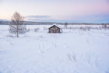 Poster Cabin in a cold winter landscape in Lapland inside the Arctic Circle in Finland © Matthew