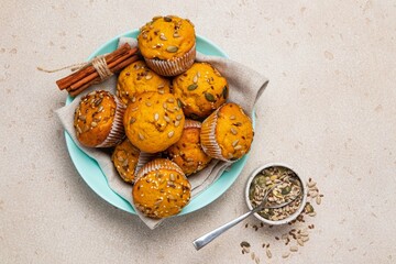 Pumpkin muffins with spices and seeds on light background. Copy space, top view. Autumn, halloween,...