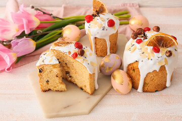 Delicious Easter cakes and eggs on white wooden background
