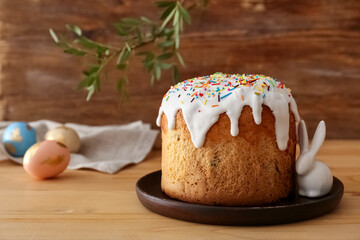 Plate with delicious Easter cake on wooden background