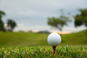golf ball on tee in morning sunrise background