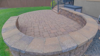Obraz premium Panorama Puffy clouds at sunset Outdoor patio of a house with curved brick wall and flooring