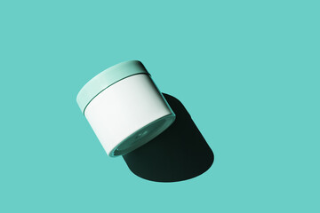 Mock up container on light blue background with shadow. Skincare, bodycare beauty product in plastic jar. White unbranded creme pot. Concept of cosmetic presentation and exhibitions. Abstract minimal