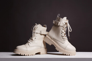 white boots on wooden table. fashion shoes still life