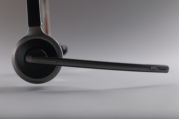 Headphones with microphone floating in air on grey background