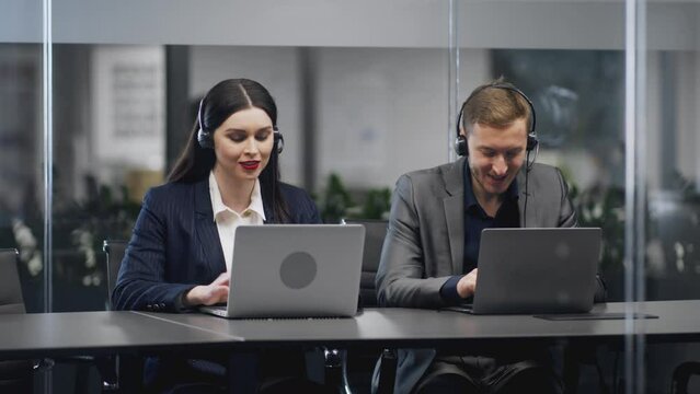 Team of customer service representatives in headsets assisting clients, resolving technical issues at modern call centre