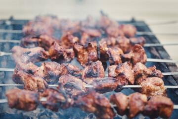 Large pieces of meat on a skewer are cooked on the grill - 485736509