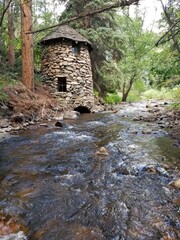 Old Stone Tower and Trees Along Mountain Stream in Colorado Forest