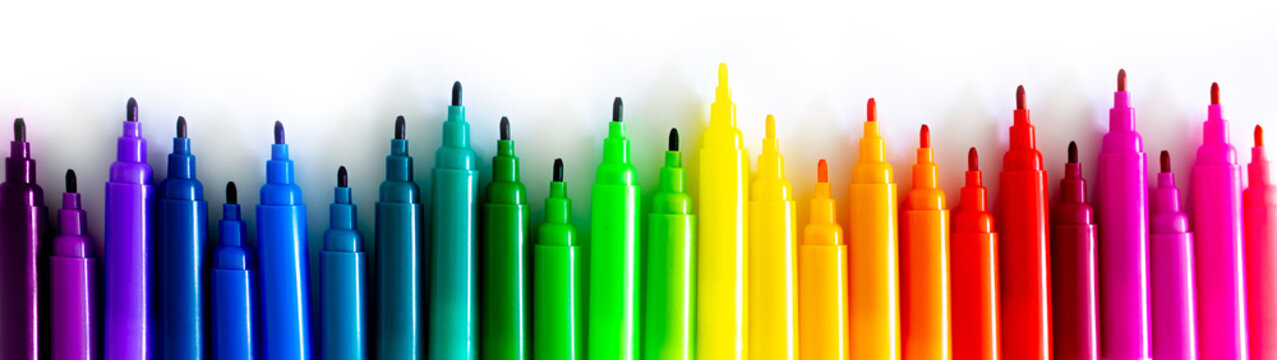 Felt-tip pens on a white background. Multi-colored markers are beautifully folded by the color of the rainbow. Creativity and design concept.