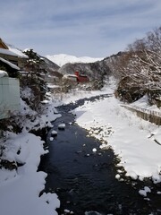 Snow Covered Buildings and Stream of Japanese Hot Springs Town Minakami Gunma Japan