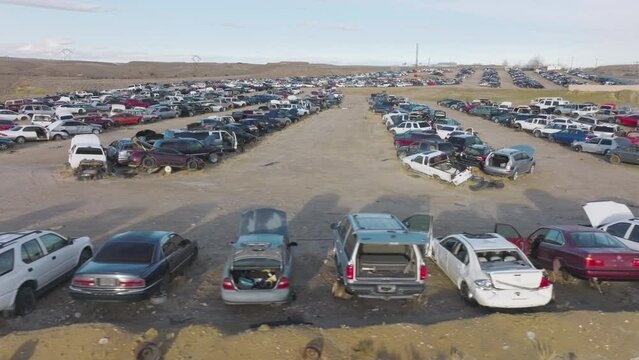 Aerial footage of the junk yard within barren deserted landscape. Massive, dense car dump in empty abandoned terrain as seen from above. High quality 4k footage