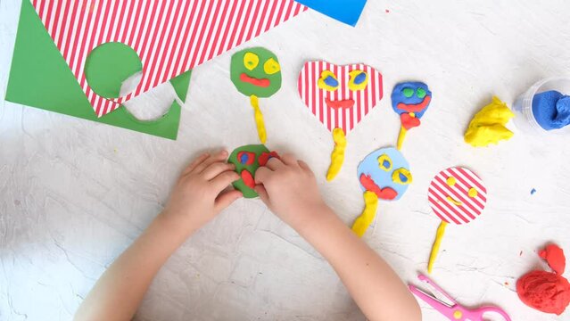 Child modeling  craft with fun face. Modeling clay, plasticine and paper crafts idea for kids. Activity in kindergarten and at home. The creative process. Kindergarten and school development