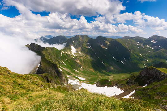 landscape of fagaras mountains in summer. beautiful nature scenery of romania. steep hills, grassy meadows and rocky peaks on a sunny day. popular travel destination