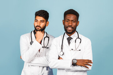 сloseup portrait of intellectual healthcare professional with white labcoat discussing findings with young doctor on blue background