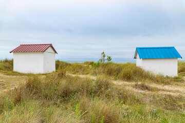 Fototapeta na wymiar Gouville-sur-Mer, Normandy, colorful wooden beach cabins in the dunes 