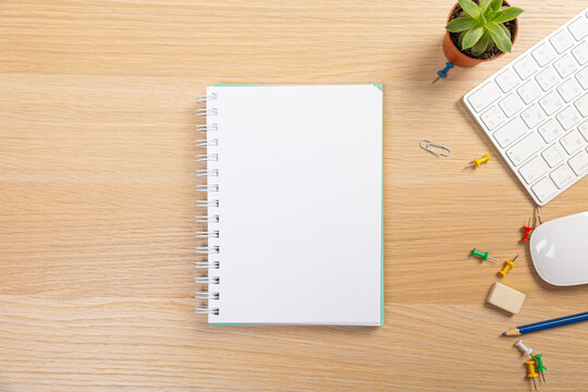 office stuff with pen and notepad keyboard on light wooden table top view. work at home