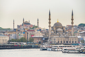 Obraz premium New Mosque (Yeni Cami) at sunset with Hagia Sophia (Aya Sofya) behind seen across the Golden Horn, Istanbul, Turkey, Eastern Europe