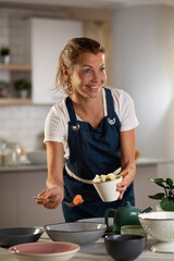 Young woman setting a table for lunch. Smiling happy woman preparing a delicious food