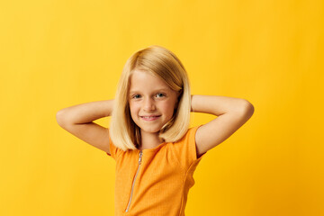 Fototapeta na wymiar cute little girl blonde straight hair posing smile fun yellow background unaltered